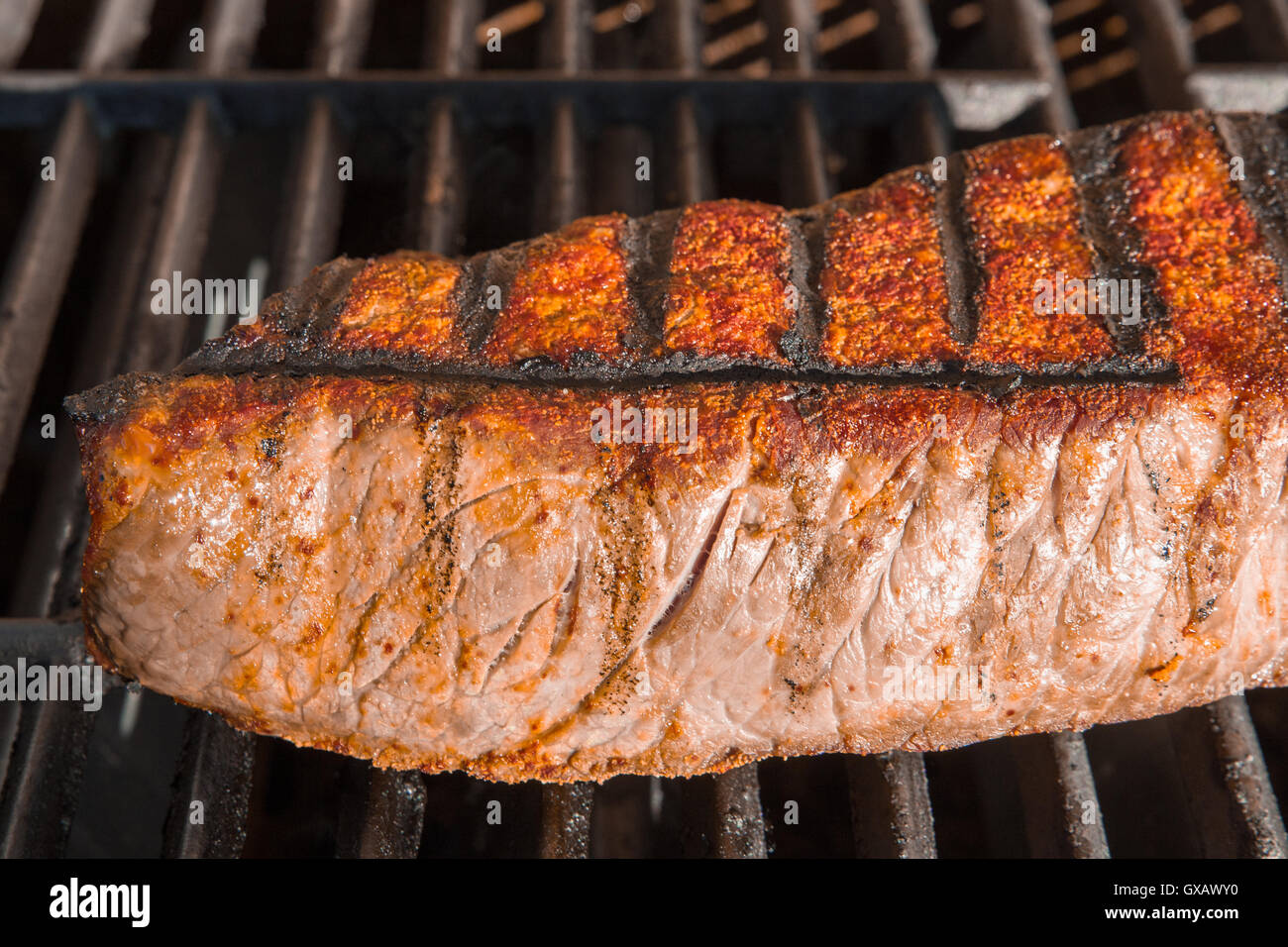 London Broil cut of beef steak on barbecue grill cooking Stock Photo