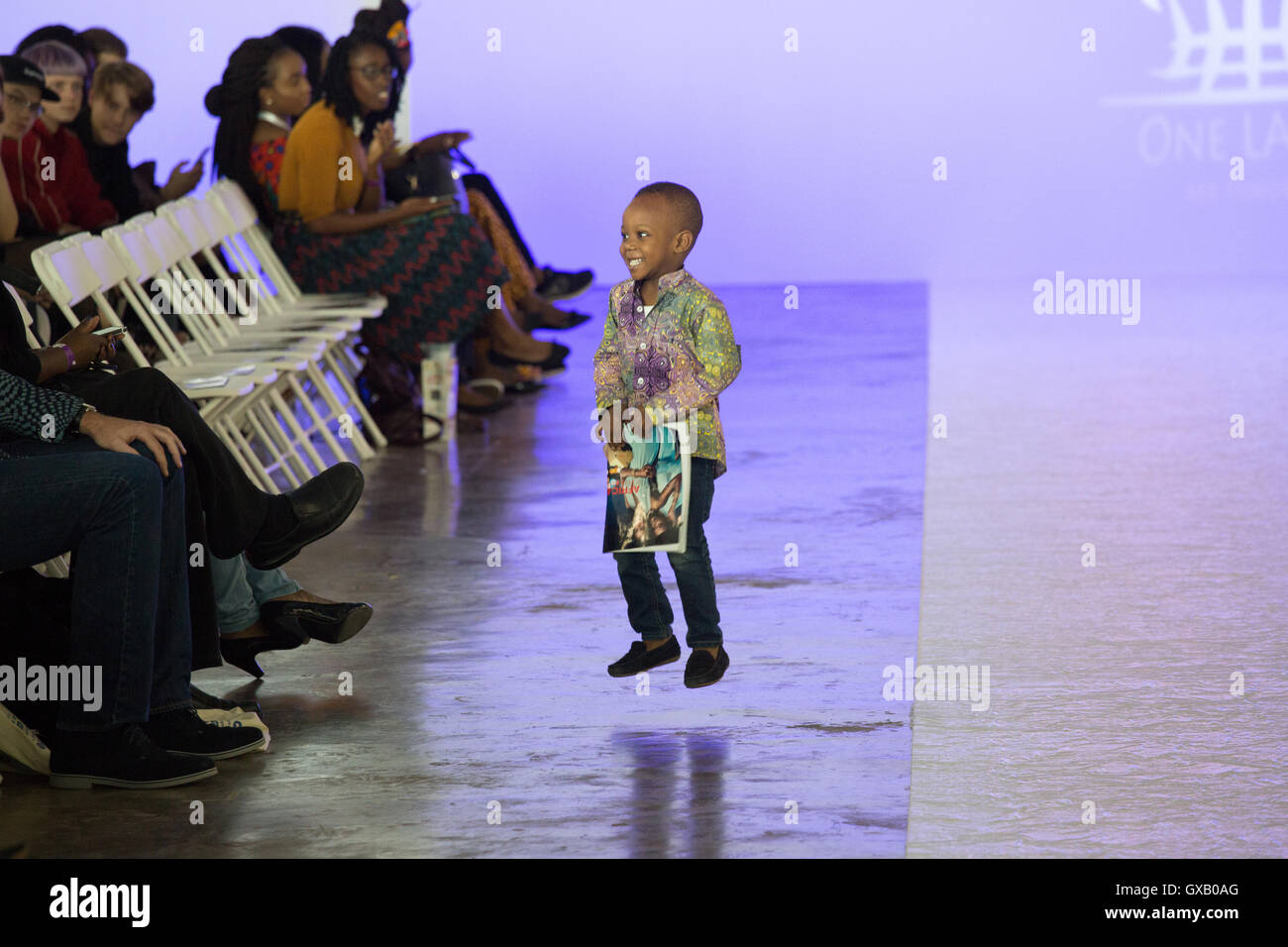 Kid jumping and playing before the beginning of the show at the Africa Fashion Show London held ay the West Hall Olympia. Stock Photo