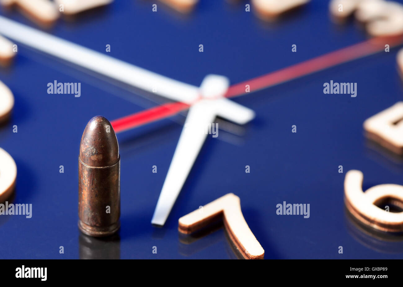 Deadline concept. Gun cartridge standing on clock face Stock Photo