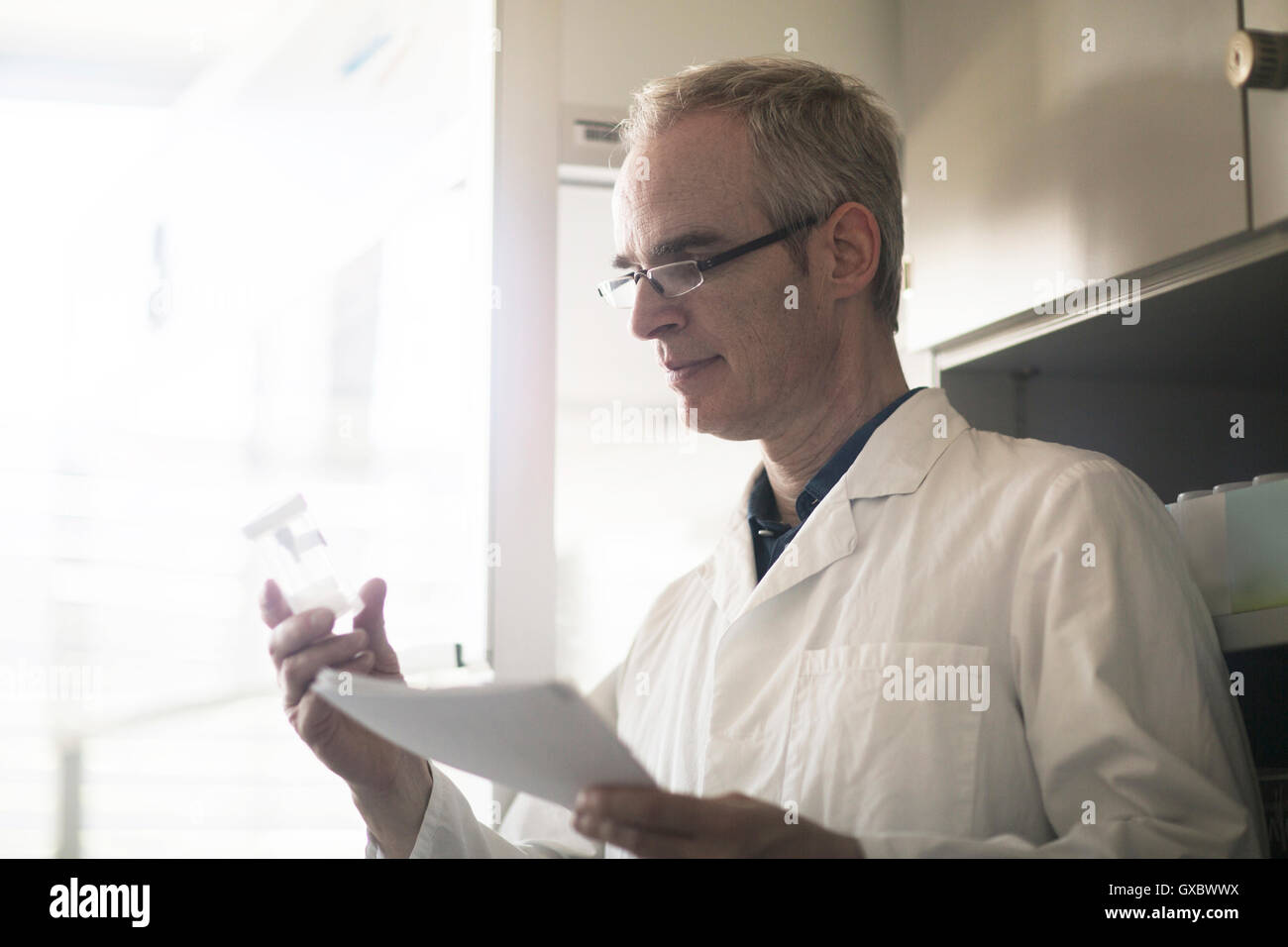 Meteorologists Male Male meteorologist examining sample bottle in weather station ...