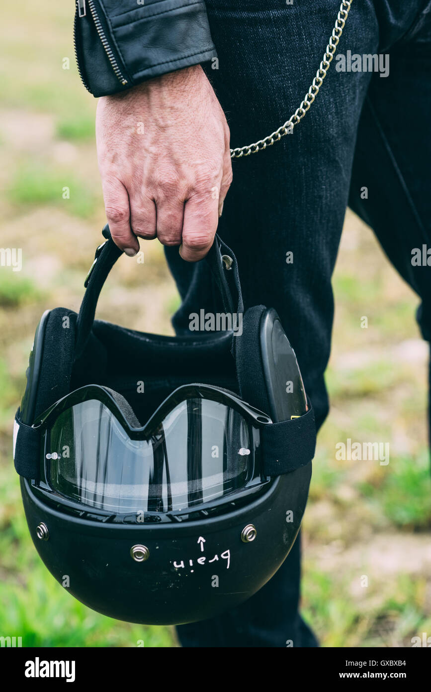 Hand of male motorcyclist holding black crash helmet Stock Photo