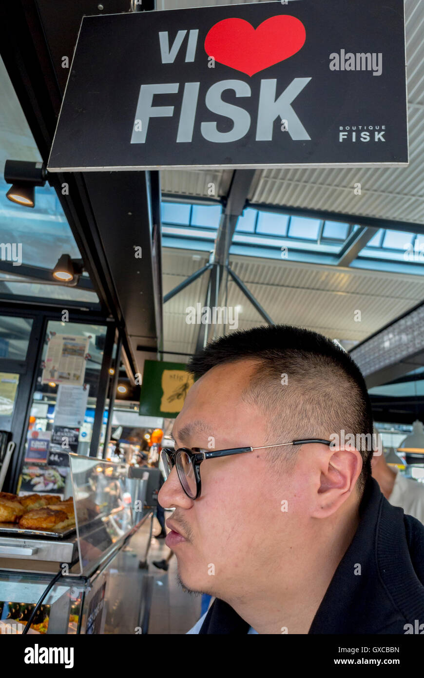 Copenhagen, Denmark, Portrait, Chinese Tourist at Fish Shop in Torvfhallerne Food Market Stock Photo