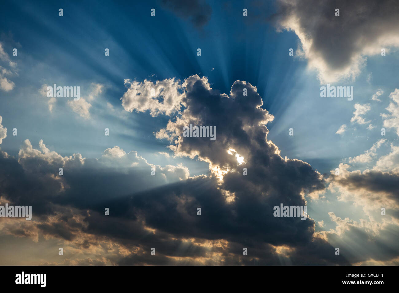 Sun rays are striking through the clouds like an explosion Stock Photo