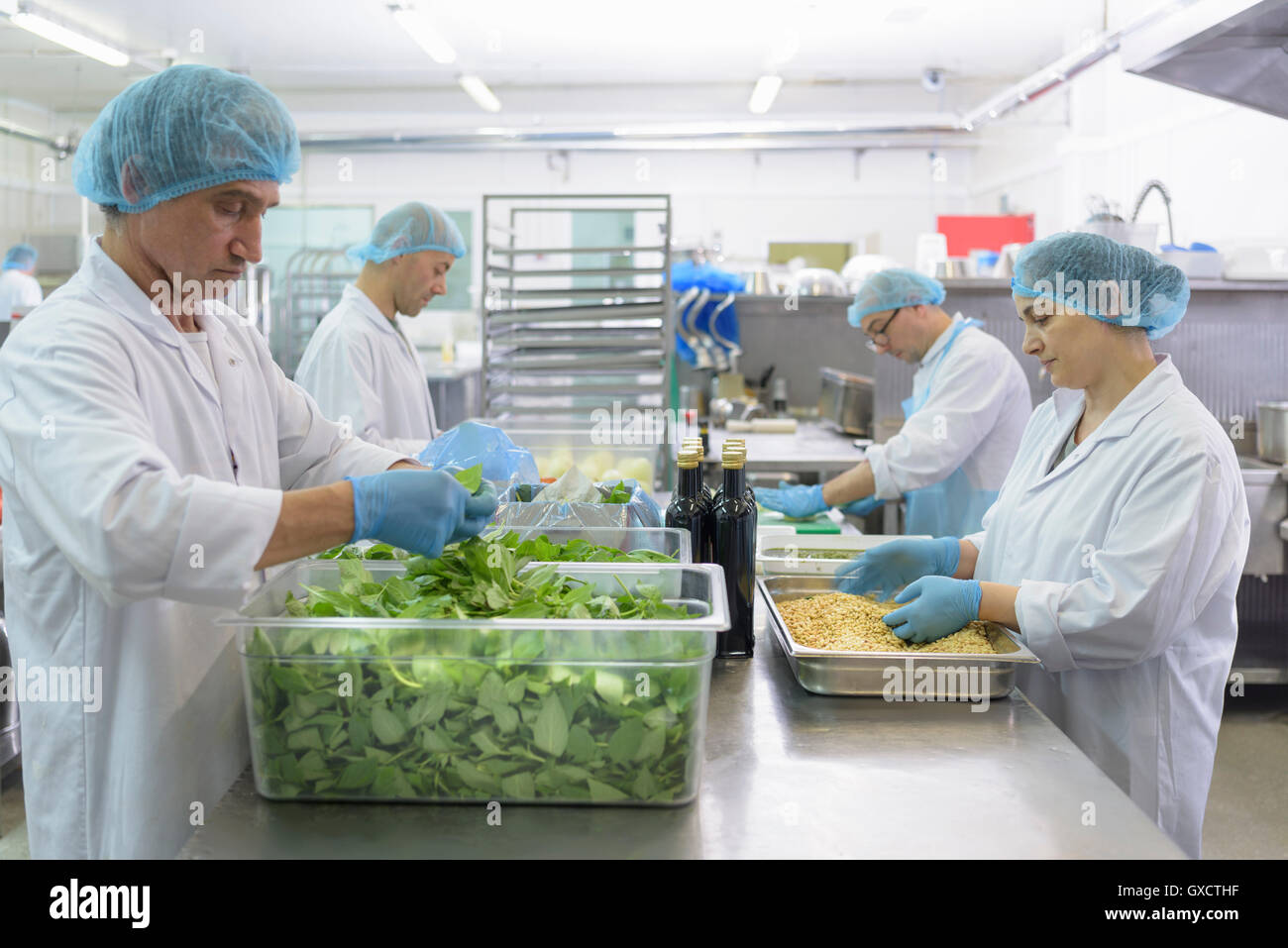 Workers hand making pesto sauce in pasta factory Stock Photo