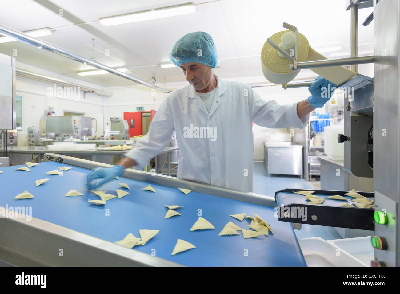 Worker sorting ravioli in pasta factory Stock Photo