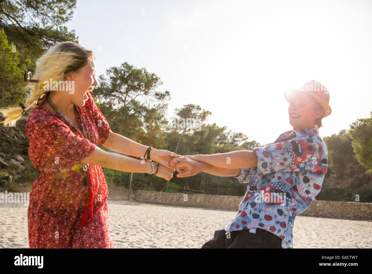 Couple holding hands spinning around, Majorca, Spain Stock Photo