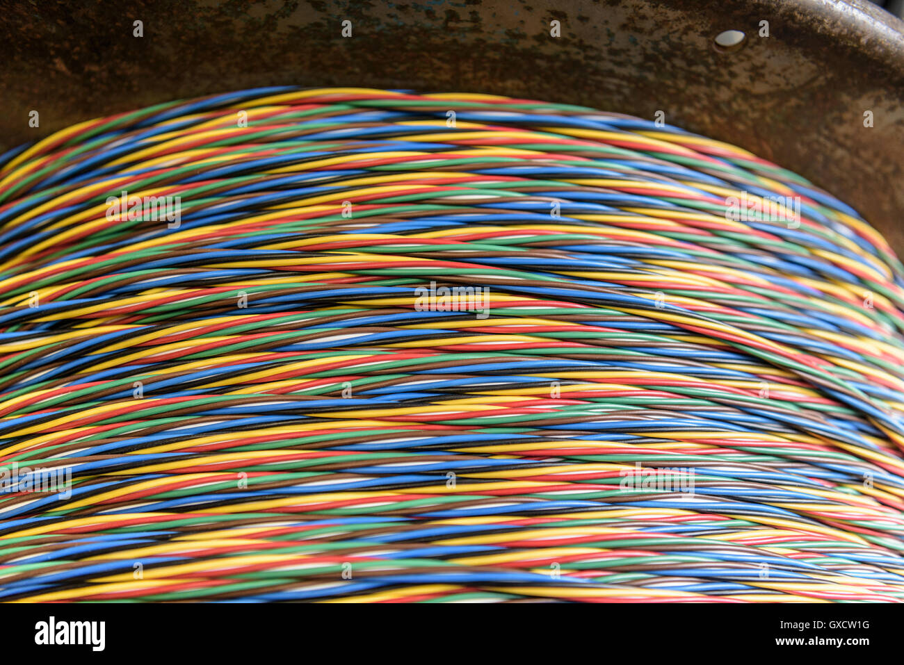 Multicoloured cable on reel in cable factory, close up Stock Photo