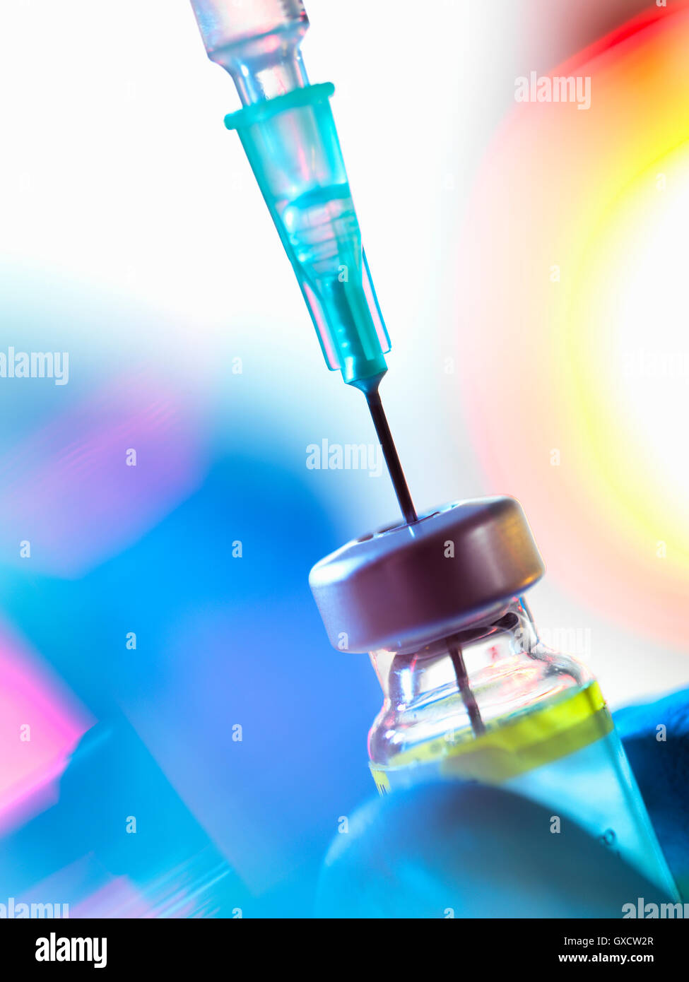 Syringe inserted into a vaccine vial Stock Photo