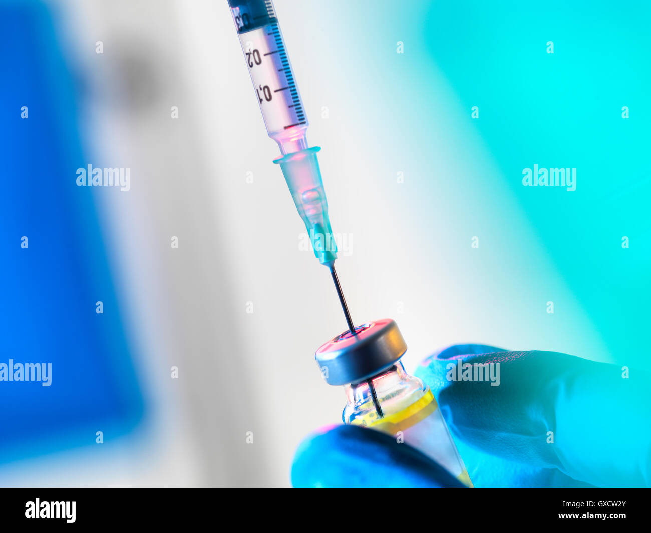 Syringe inserted into a vaccine vial Stock Photo
