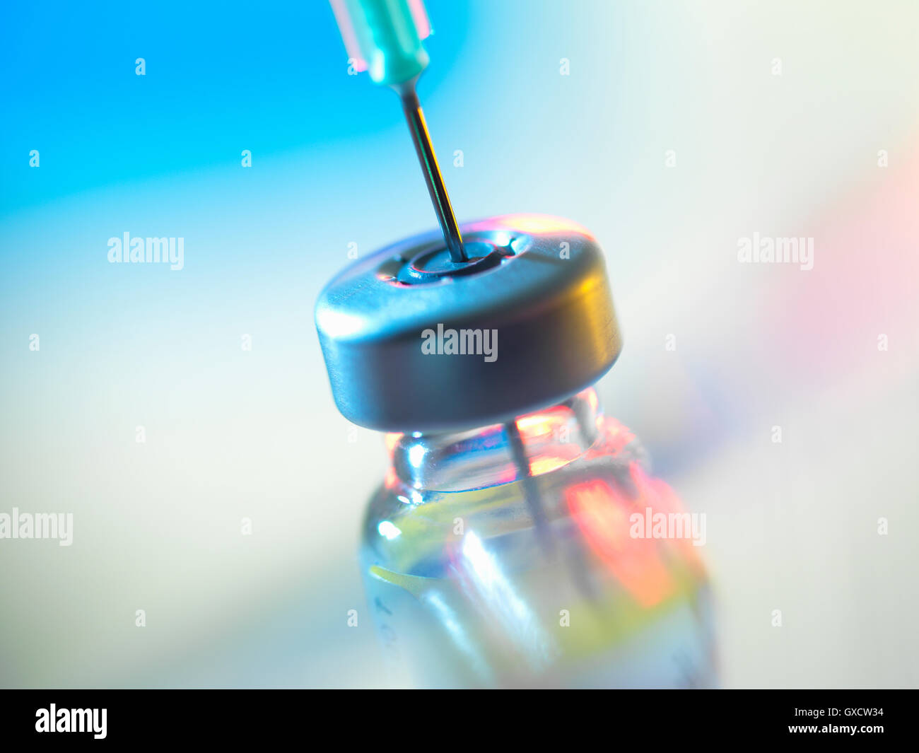 Syringe inserted into a vaccine vial Stock Photo