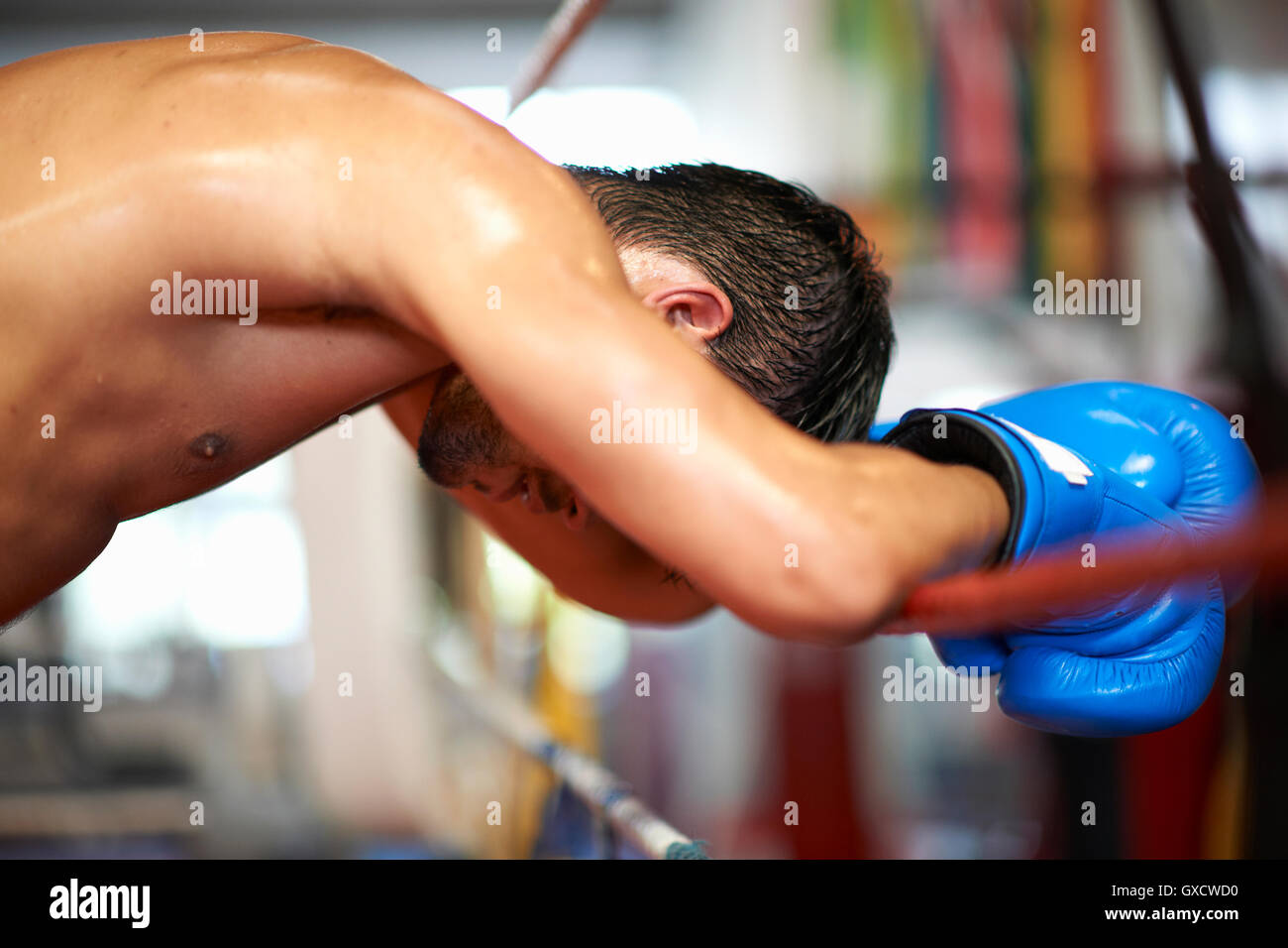 Boxer leaning on ropes of boxing ring Stock Photo - Alamy