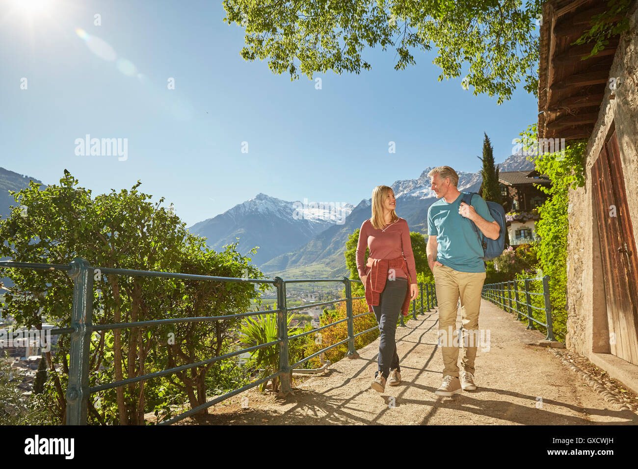 Mature couple hiking along country road, Meran, South Tyrol, Italy Stock Photo