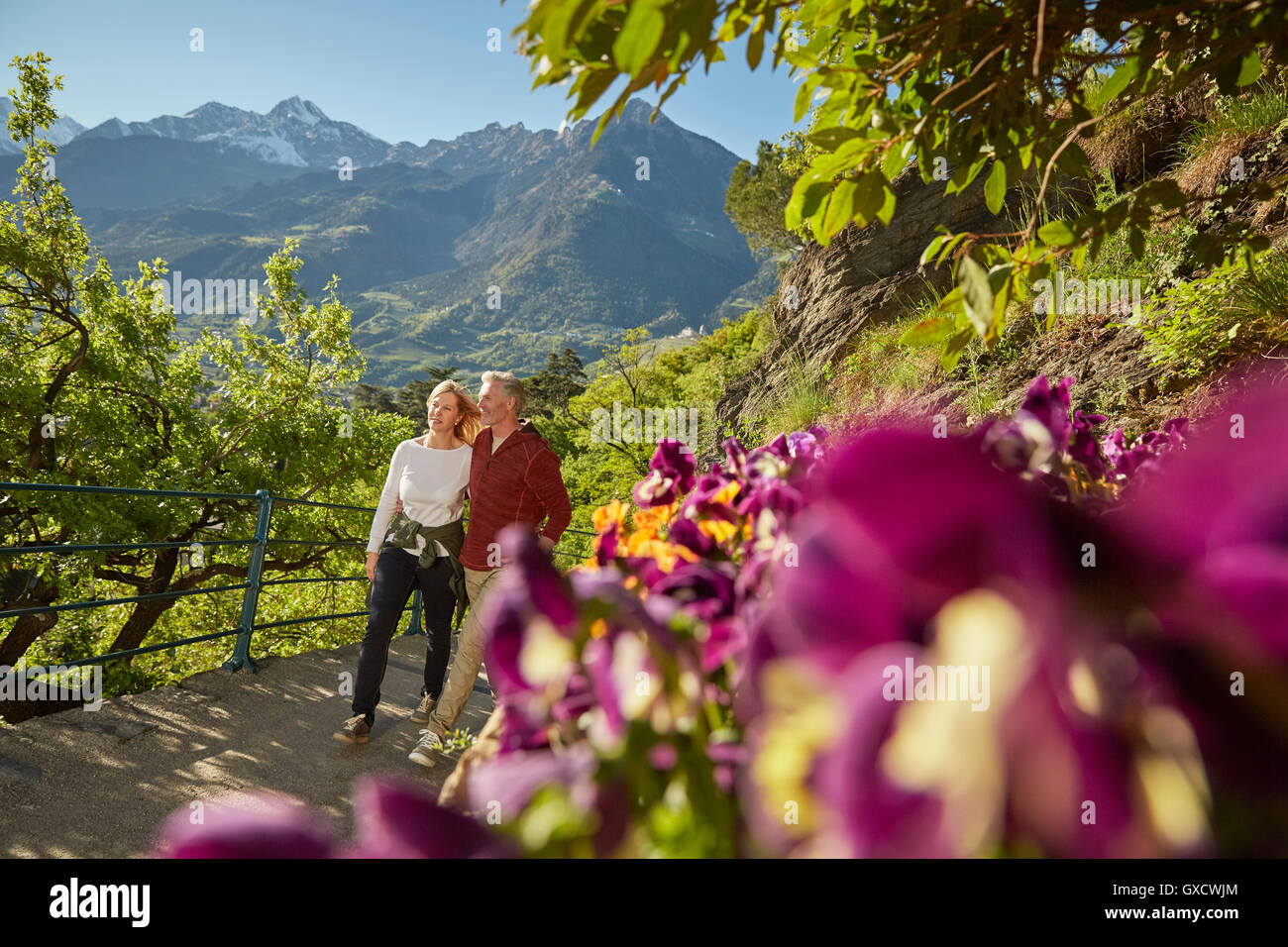 Mature couple hiking along country road, looking at view, Meran, South Tyrol, Italy Stock Photo