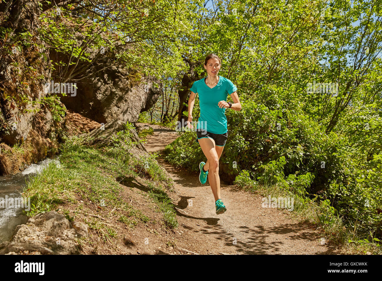 Young woman running along rural pathway, Meran, South Tyrol, Italy Stock Photo