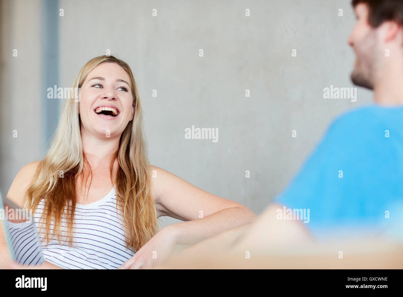 Young male and female students chatting and laughing at higher education college Stock Photo