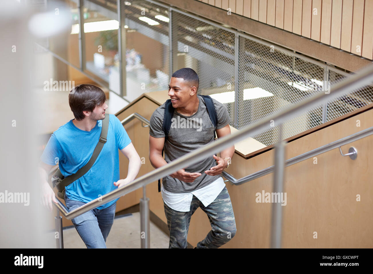 Two male students moving up stairway at higher education college Stock Photo
