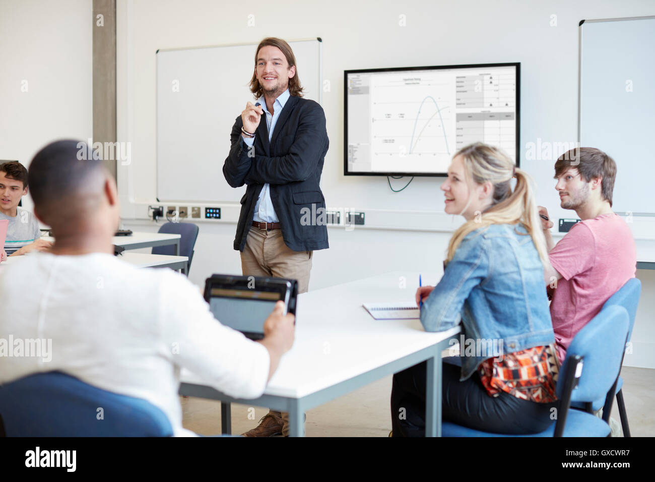 Male lecturer questioning students in higher education college classroom Stock Photo