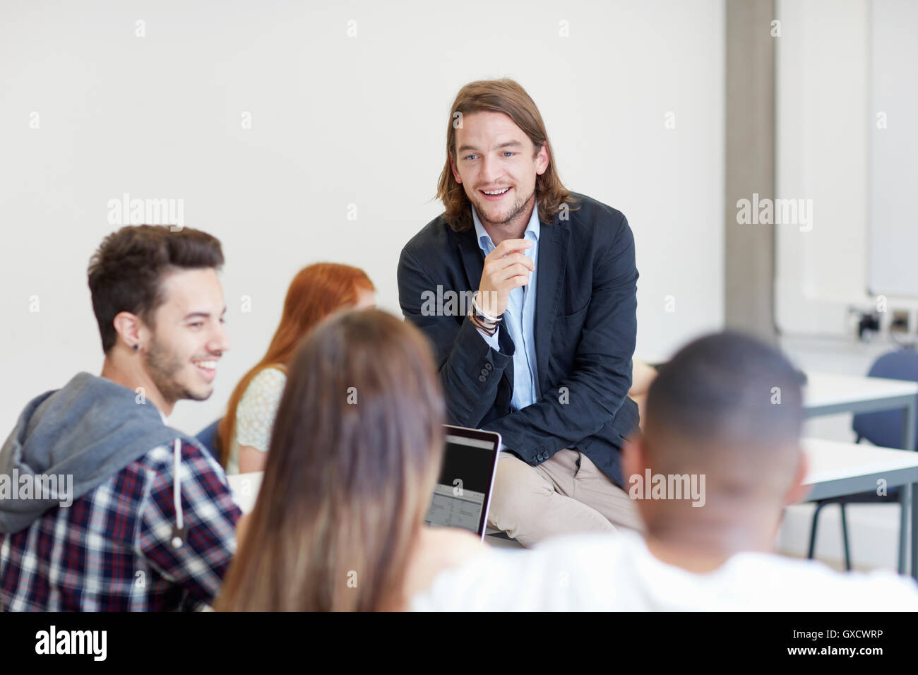 Male lecturer talking to students in higher education college classroom Stock Photo