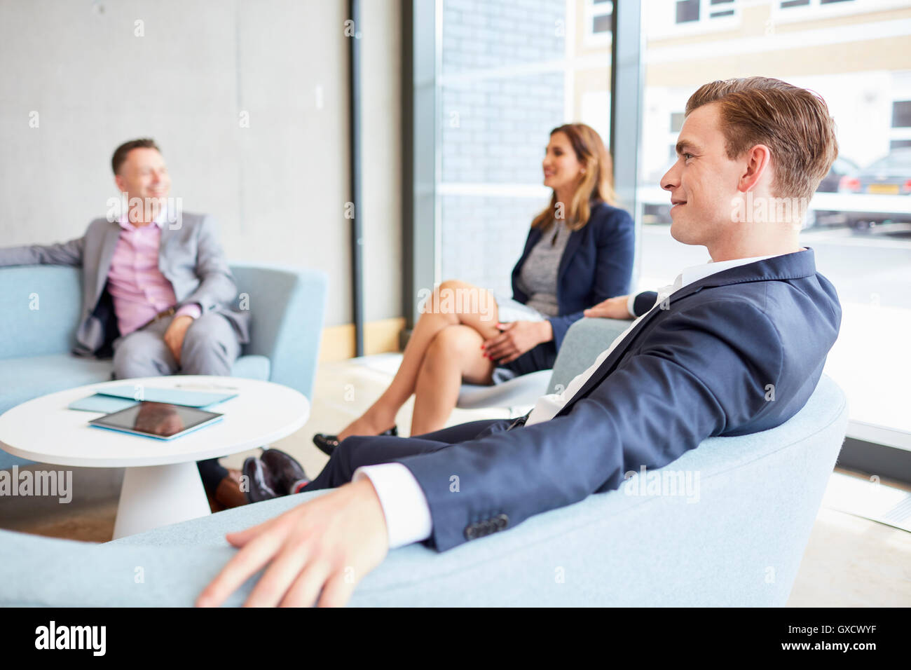 Businessmen and businesswoman meeting on office sofas Stock Photo
