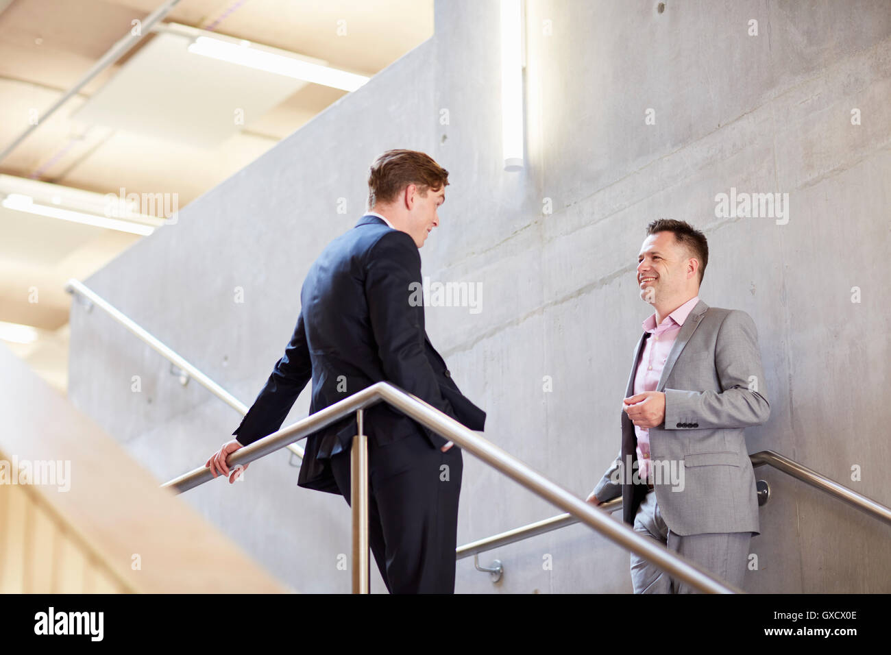 Two businessmen chatting on office stairway Stock Photo