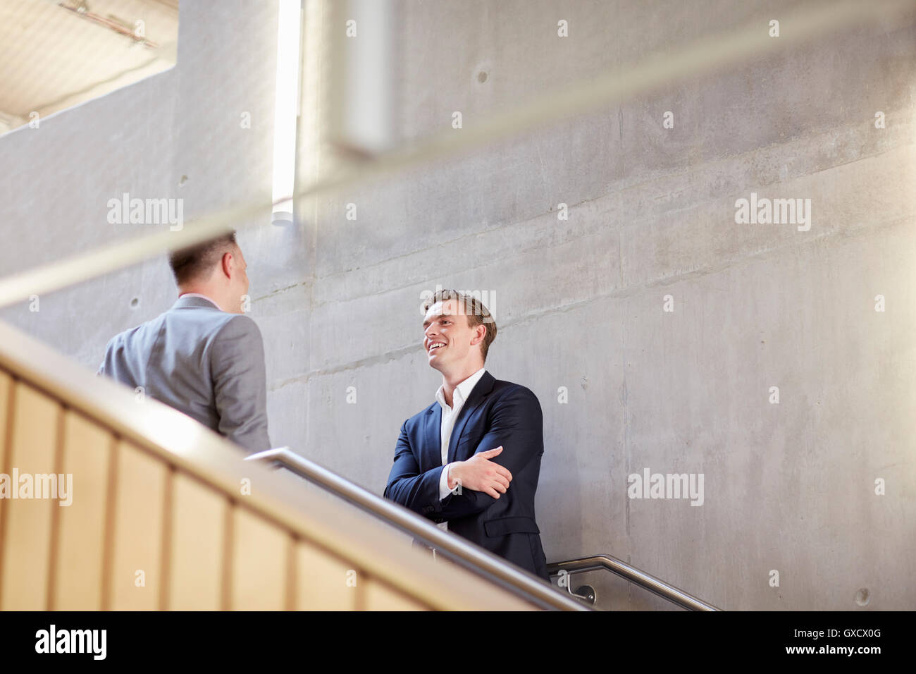 Two businessmen talking on office stairway Stock Photo
