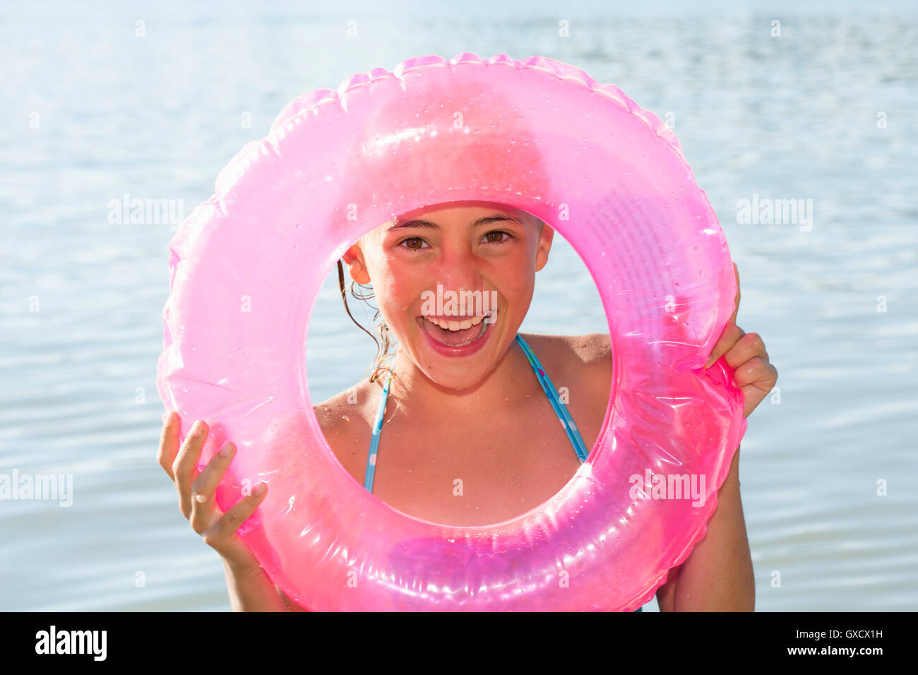 Portrait of girl holding pink inflatable ring in Lake Seeoner See, Bavaria, Germany Stock Photo