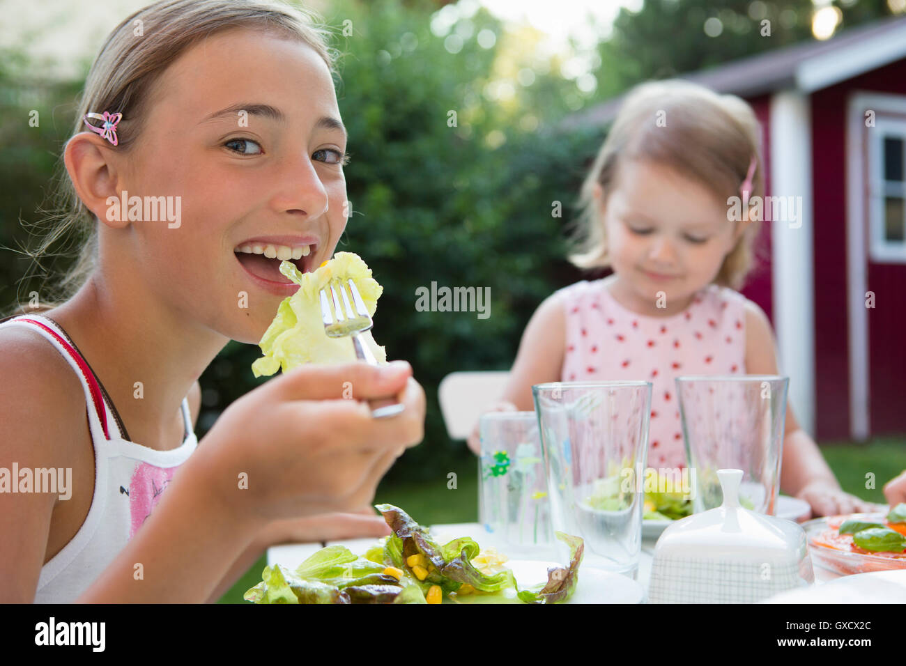 Portrait of girl eating salad in garden, Bavaria, Germany Stock Photo