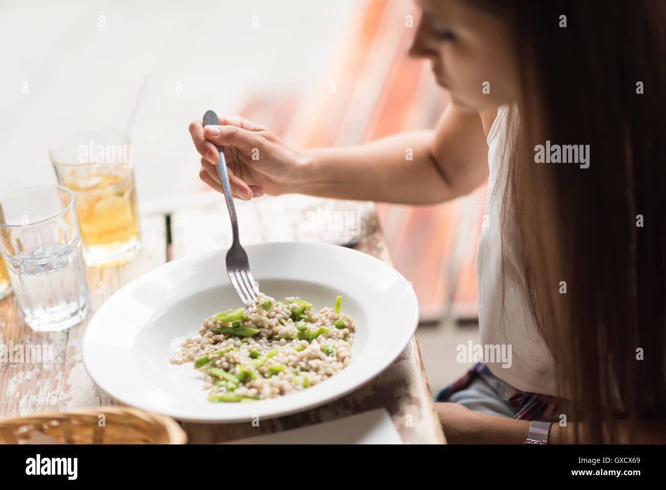 Cropped shot of young woman eating lunch in restaurant Stock Photo