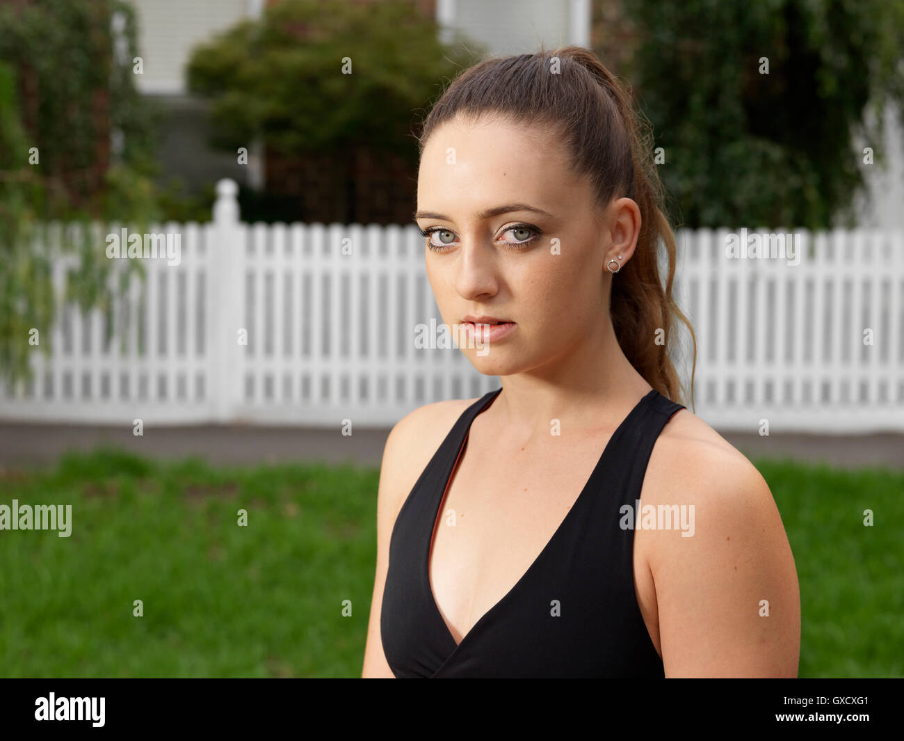 Head and shoulder portrait of young female athlete in park Stock Photo