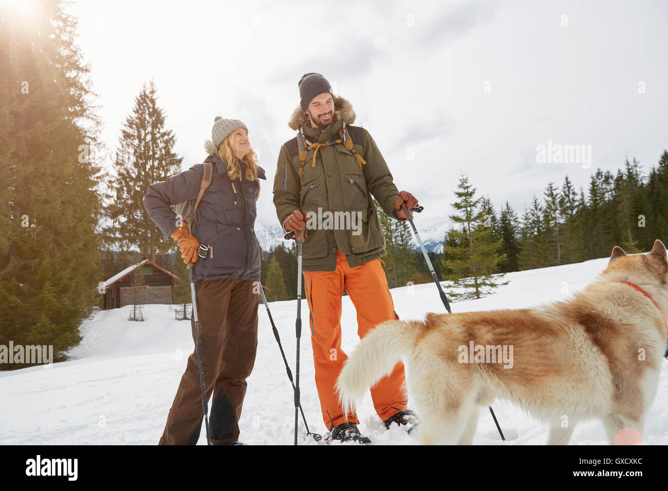 Couple snowshoeing across snowy landscape, Elmau, Bavaria, Germany Stock Photo