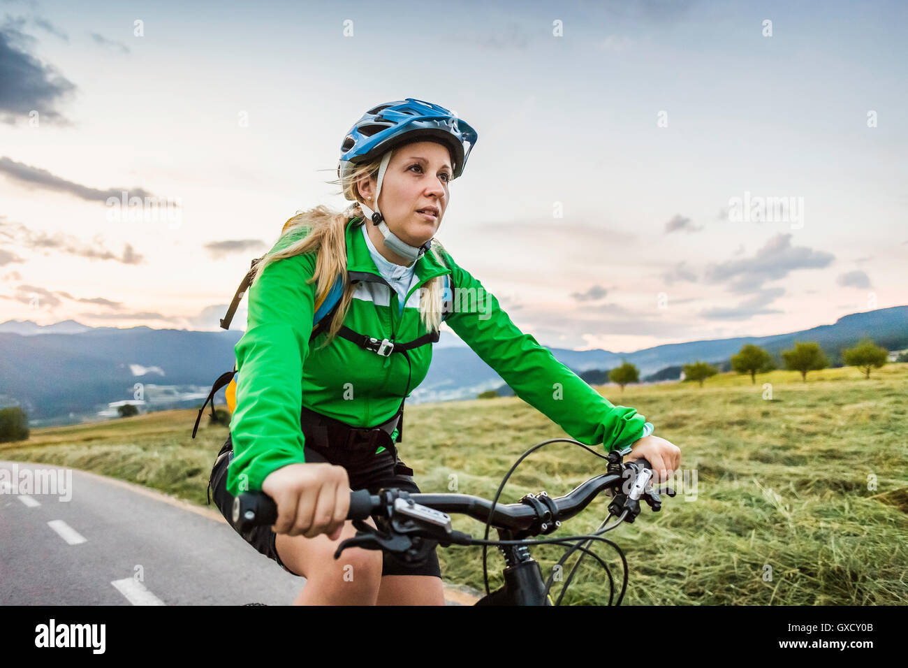 Woman cycling on road, Fondo, Trentino, Italy Stock Photo