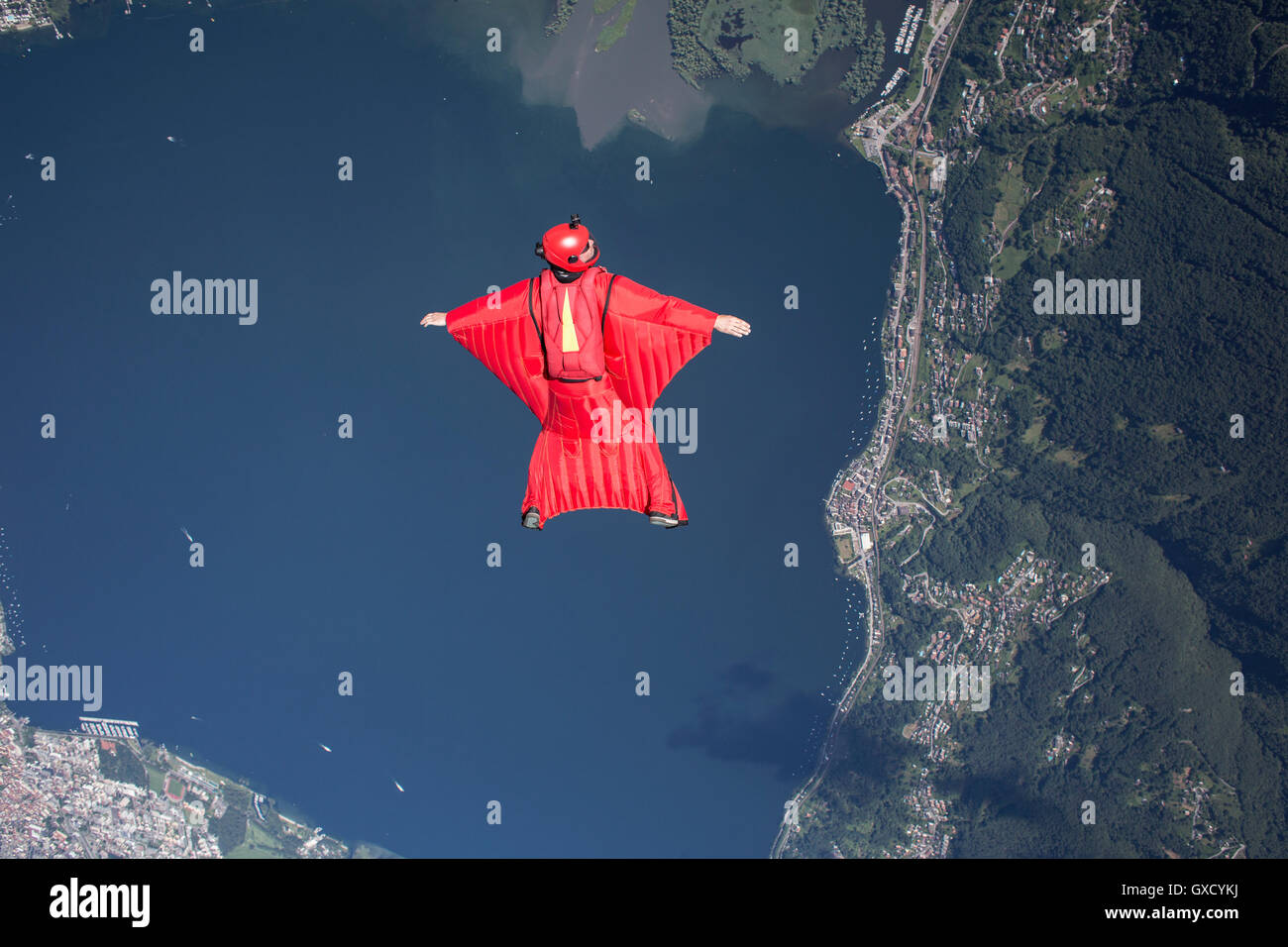 Wingsuit skydiver pilot flying over lake, Locarno, Tessin, Switzerland Stock Photo
