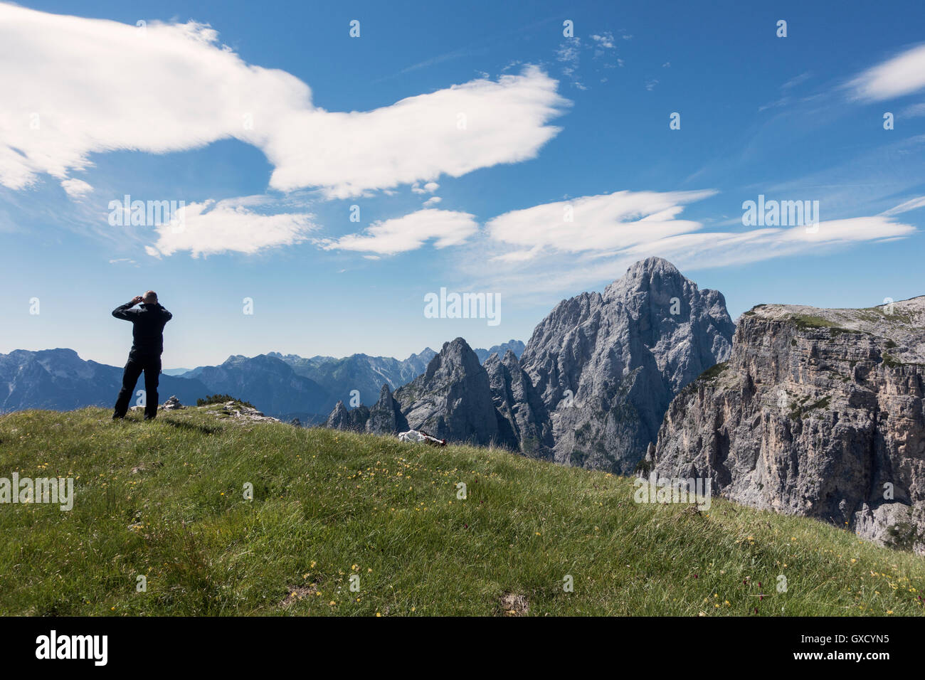 BASE jumper is checking the wind and clouds before walking to the cliff edge, Italian Alps, Alleghe, Belluno, Italy Stock Photo