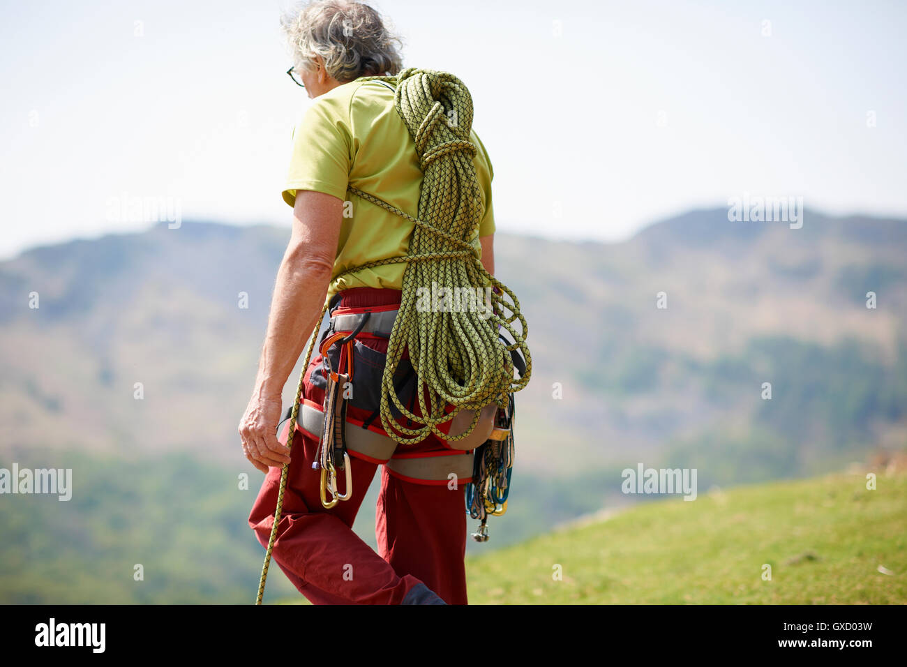 Rear view of rock climber carrying climbing rope on back Stock Photo