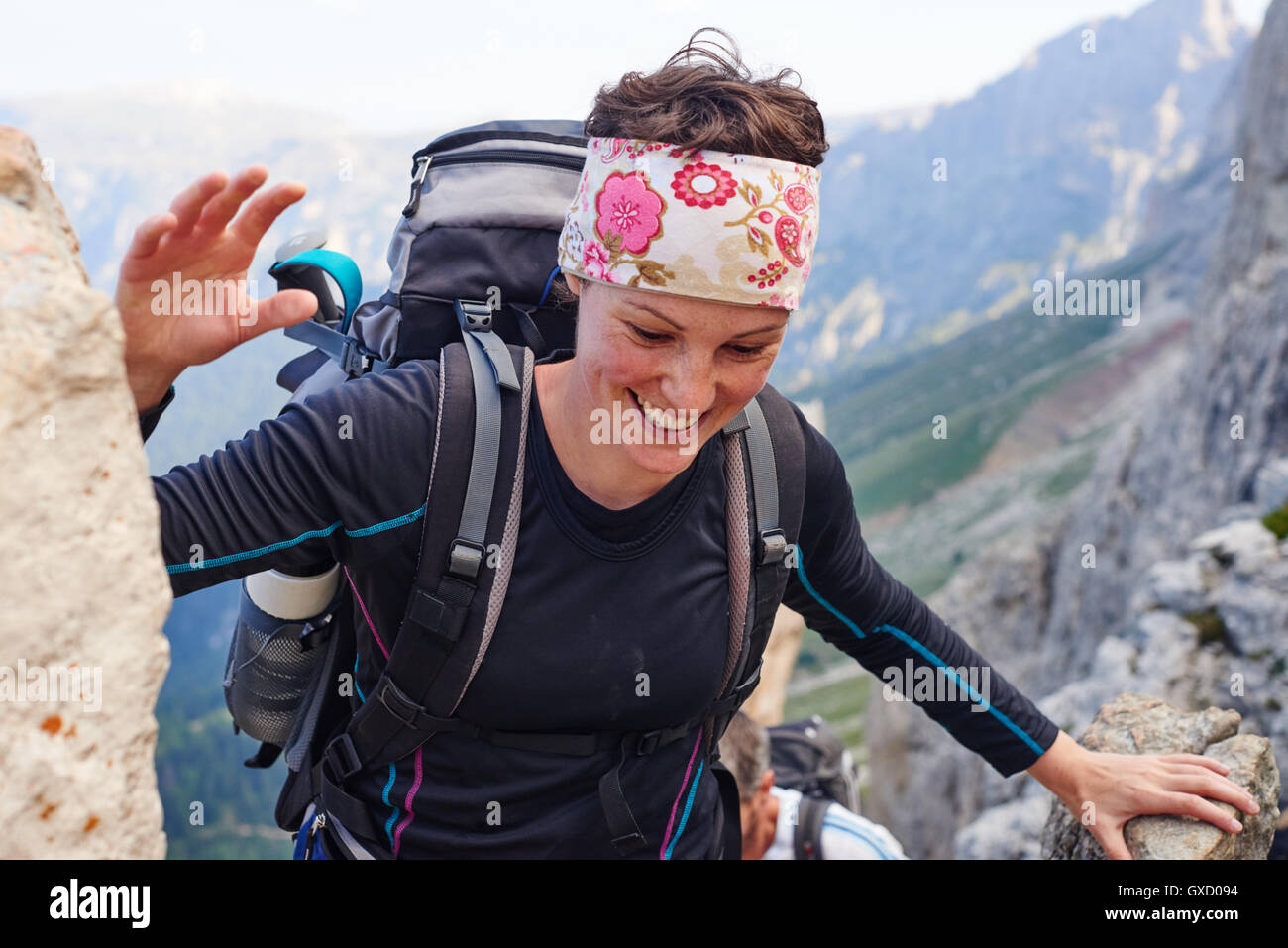 Woman hiking up mountain smiling, Austria Stock Photo