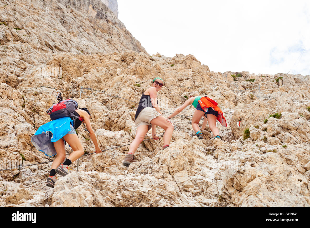 Low angle view of women hiking up rocky mountain, Austria Stock Photo