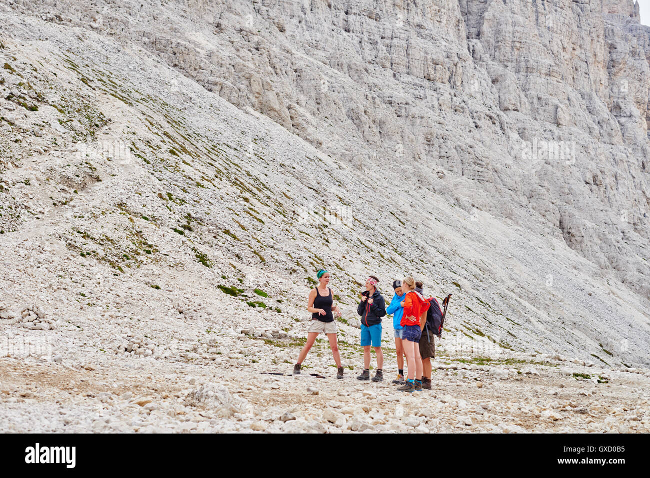 Hikers at bottom of rocky mountain, Austria Stock Photo