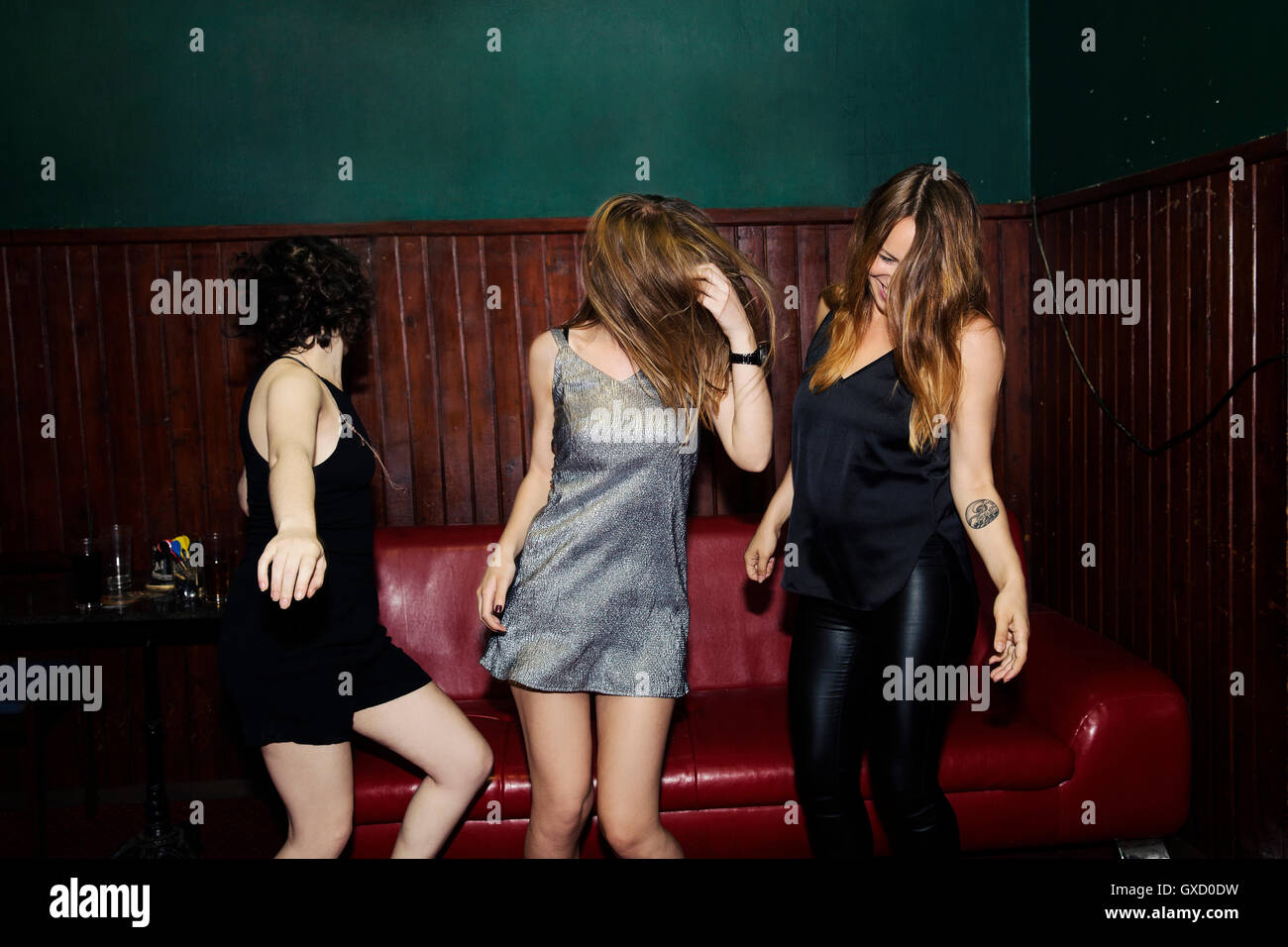Three adult female friends dancing in club on night Stock Photo
