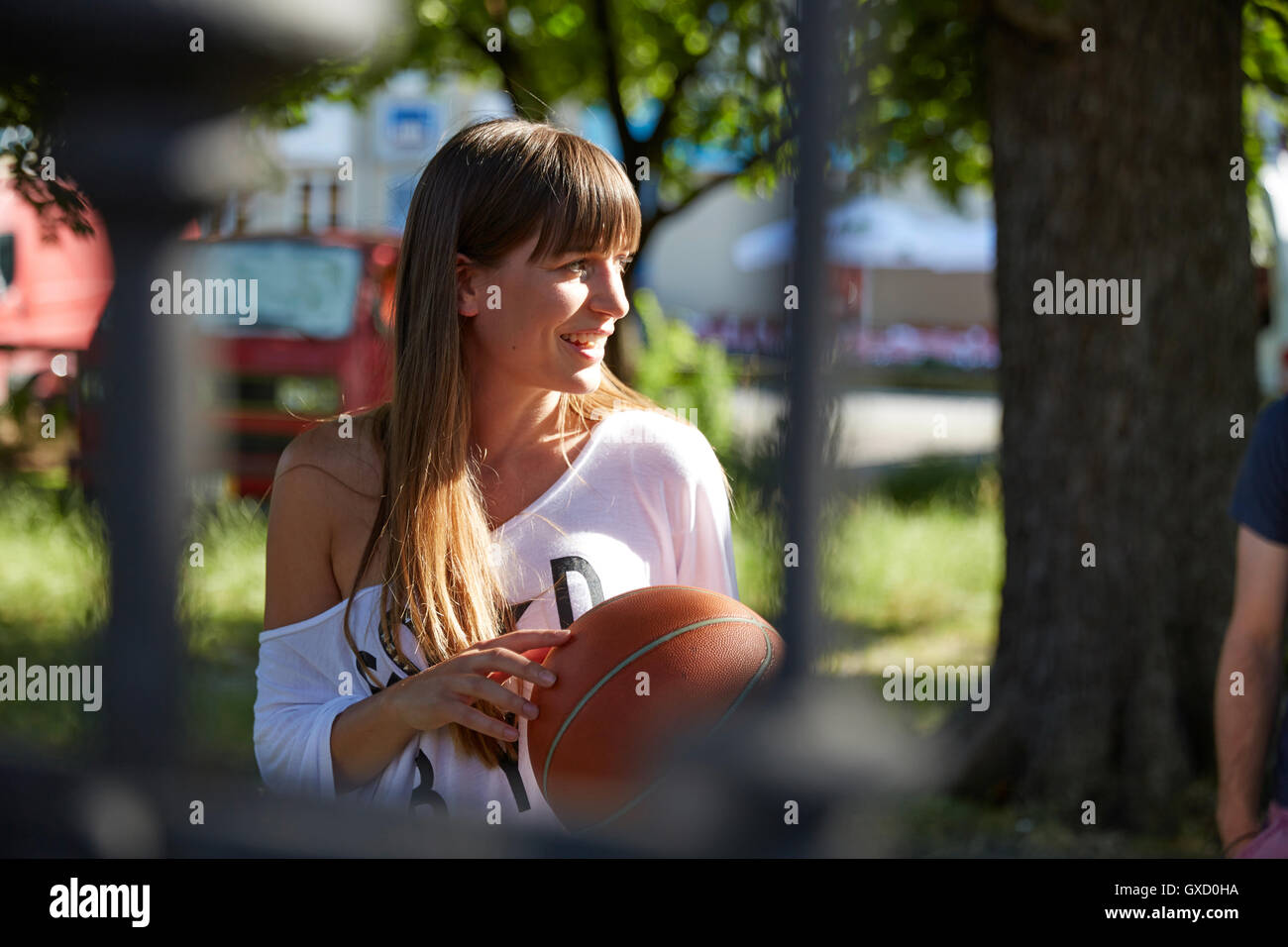 Young woman outdoors, holding basketball, smiling Stock Photo - Alamy