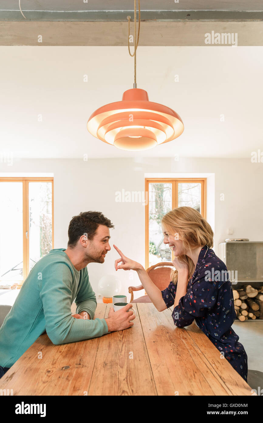 Couple face to face at dining table smiling Stock Photo