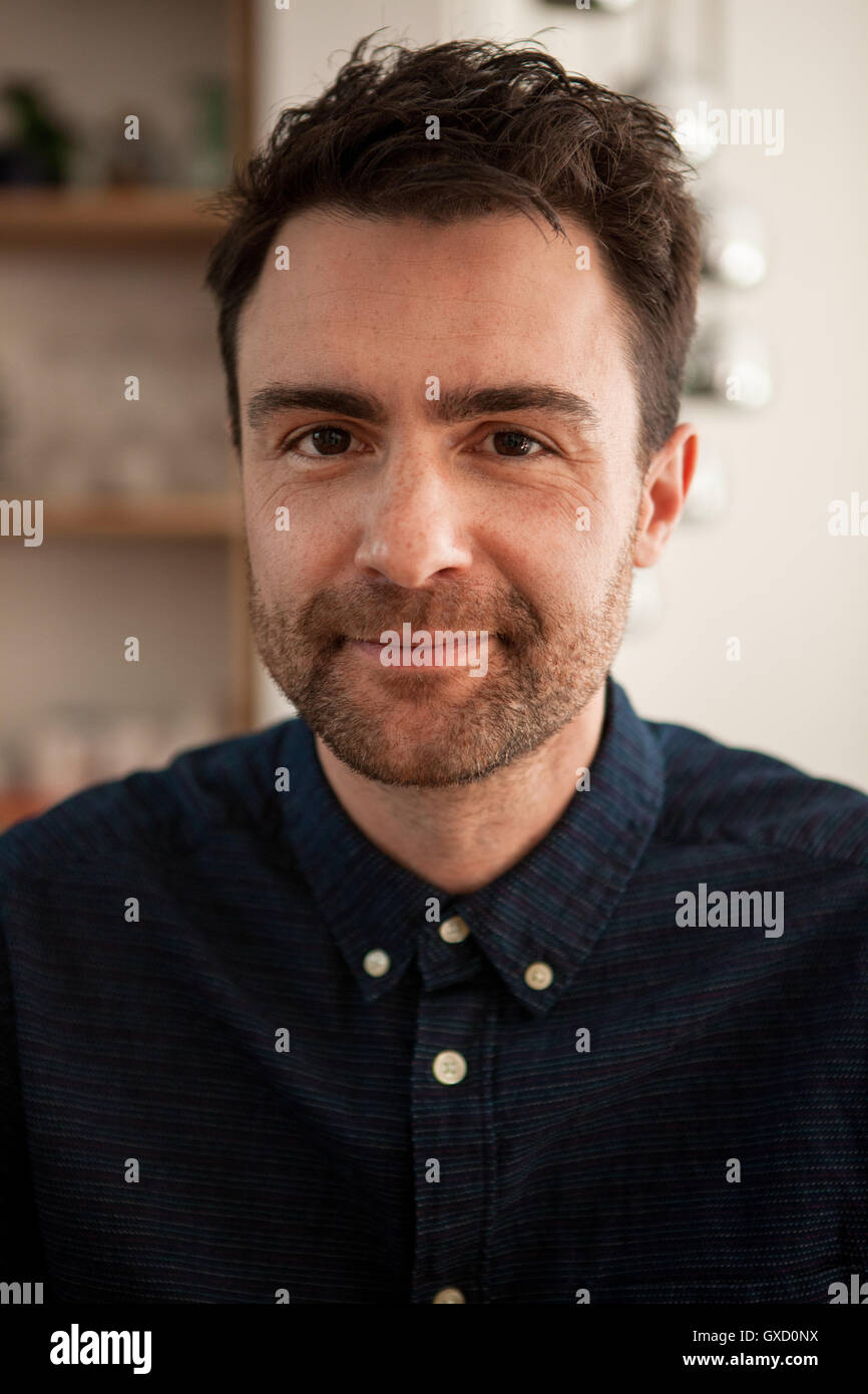 Portrait of man with stubble looking at camera smiling Stock Photo