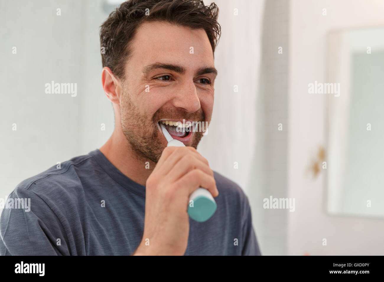 Man brushing teeth smiling Stock Photo