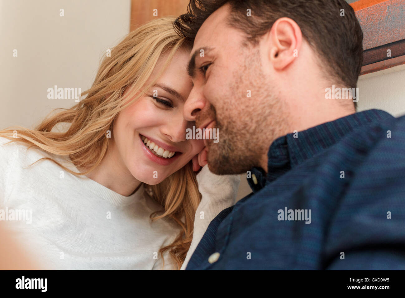 Couple snuggling together smiling Stock Photo