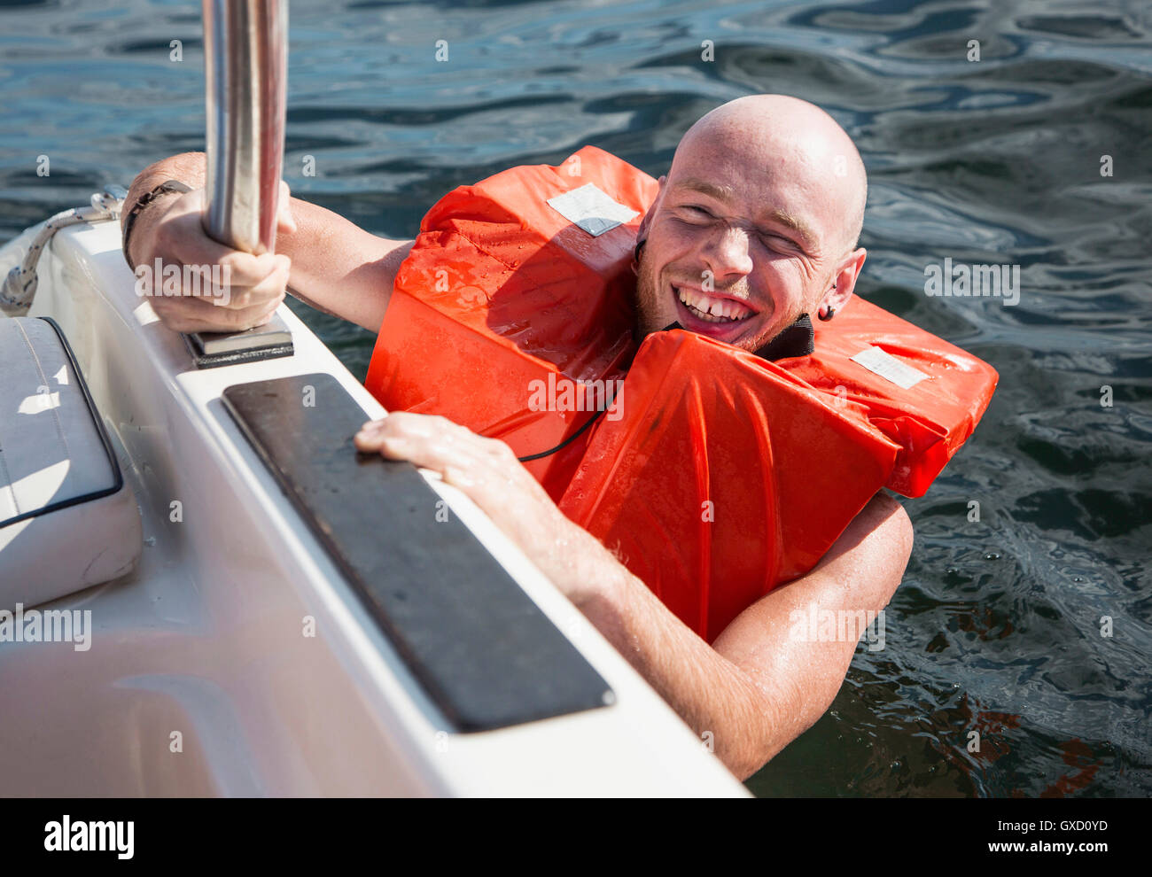 Man wearing lifejacket in water looking at camera smiling Stock Photo