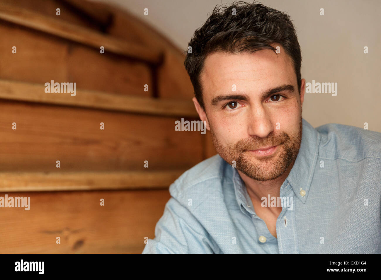 Portrait of man with stubble on stairway looking at camera Stock Photo