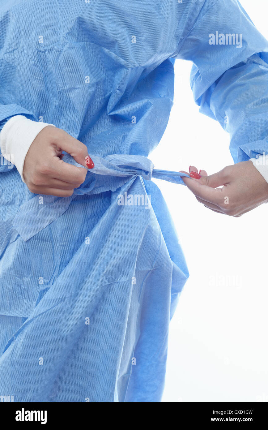 Surgeon tying belt on surgical scrub Stock Photo