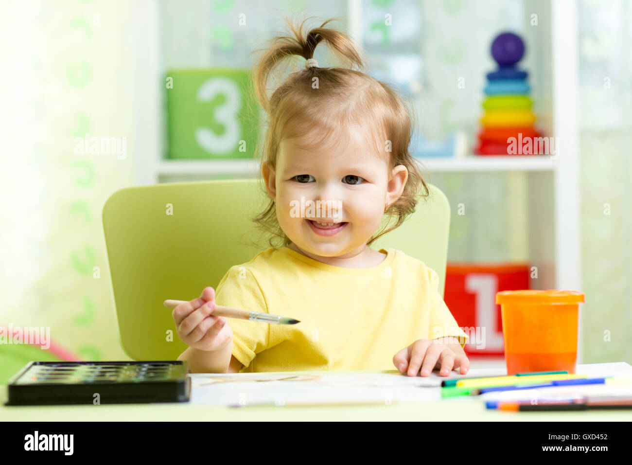 Kid girl painting with watercolors at home or school nursery Stock Photo