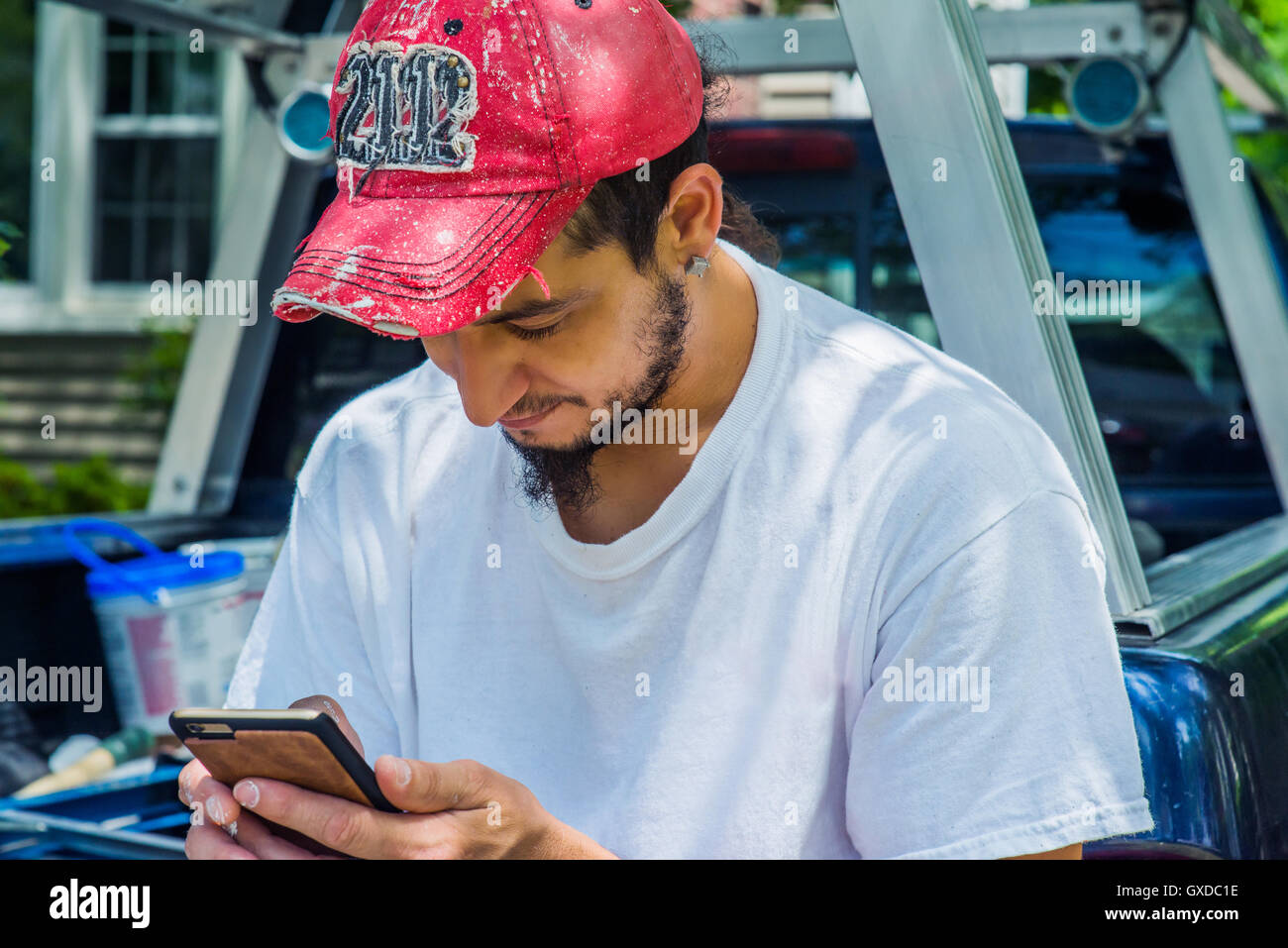 Man wearing baseball cap using smartphone Stock Photo