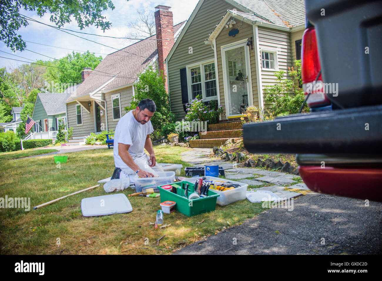 Decorator on grass sorting through decorating equipment Stock Photo