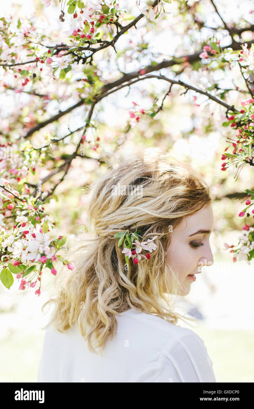 Portrait of woman by cherry blossom tree looking away Stock Photo
